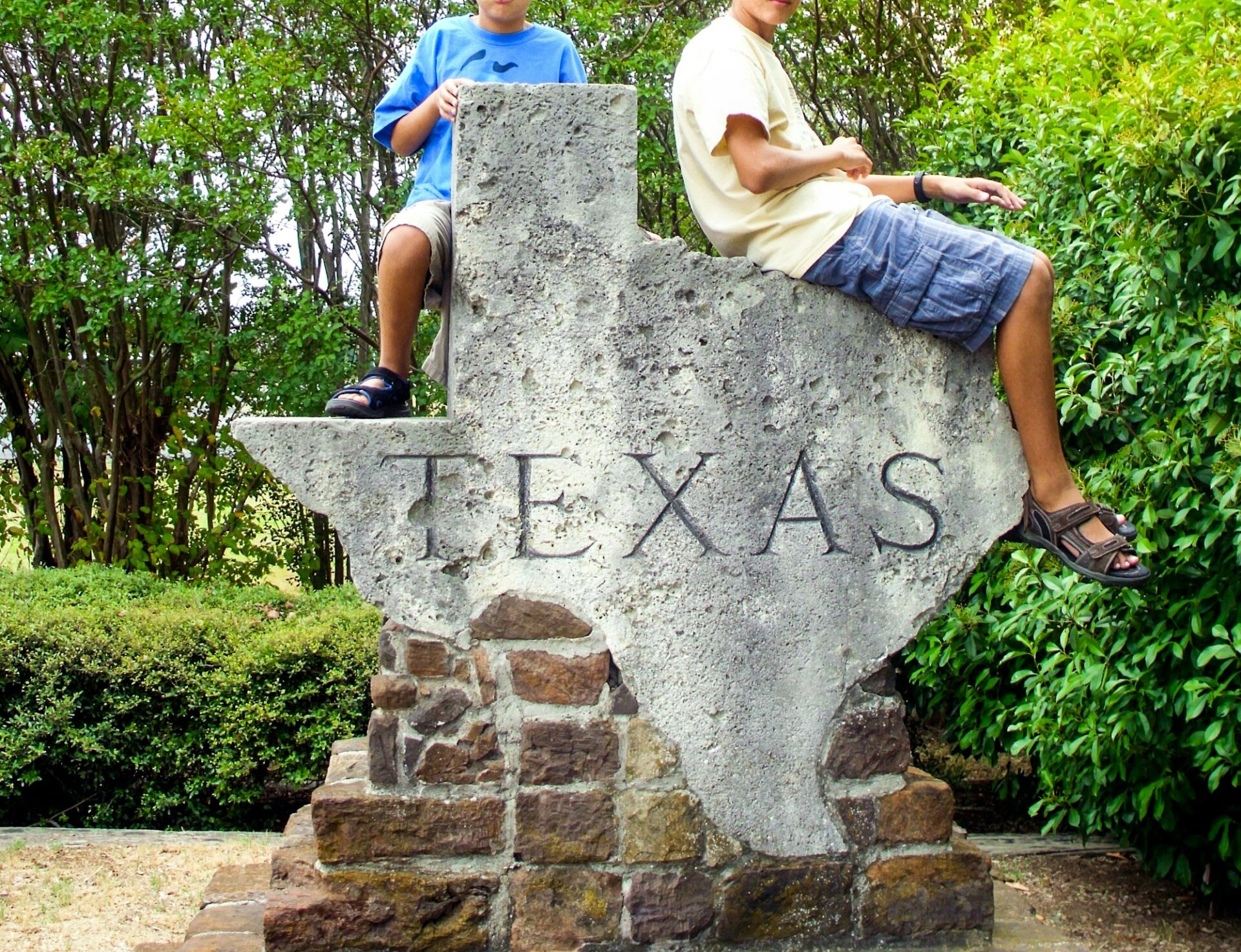 Boys sitting on a Texas map structure during a Texas trip USA travel